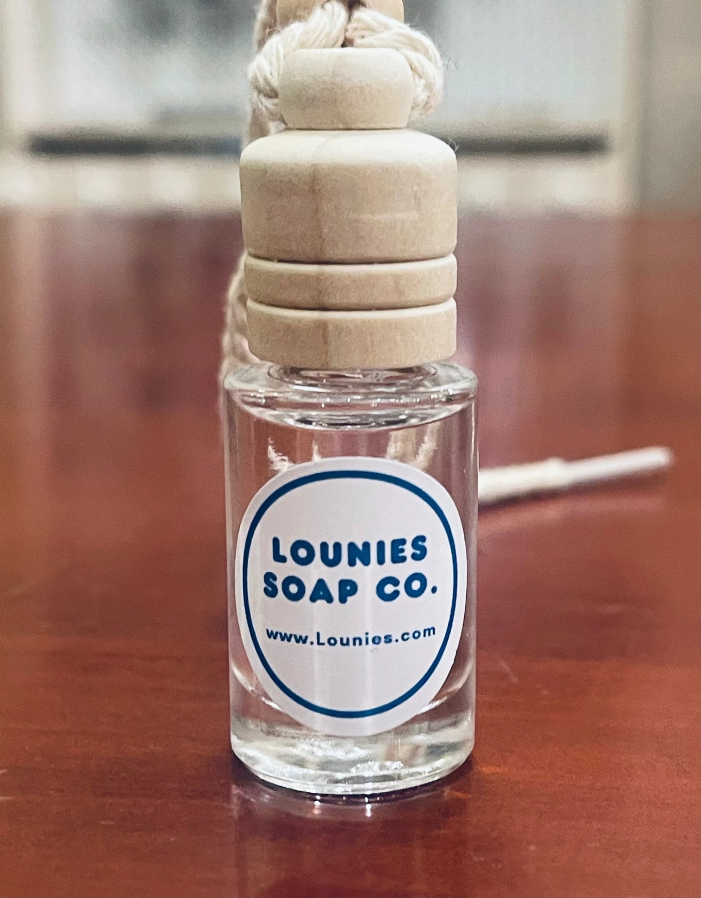 Air diffuser bottle with wooden stopper and rope, Lounies Soap Co. label.